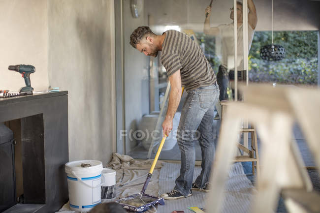 Two men in unfurnished home decorating walls — Stock Photo