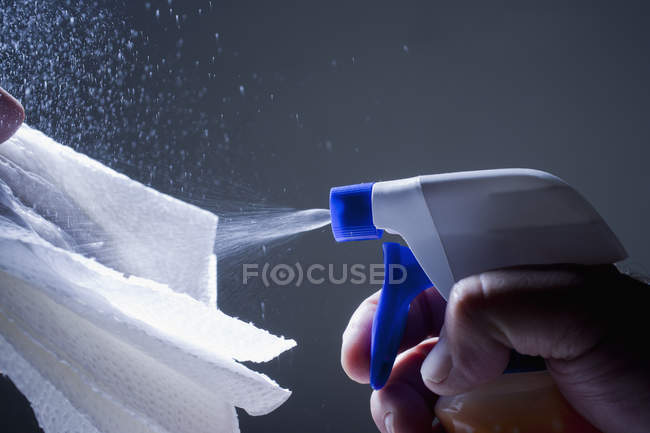 Imagem cortada do homem pulverização produto de limpeza no guardanapo — Fotografia de Stock
