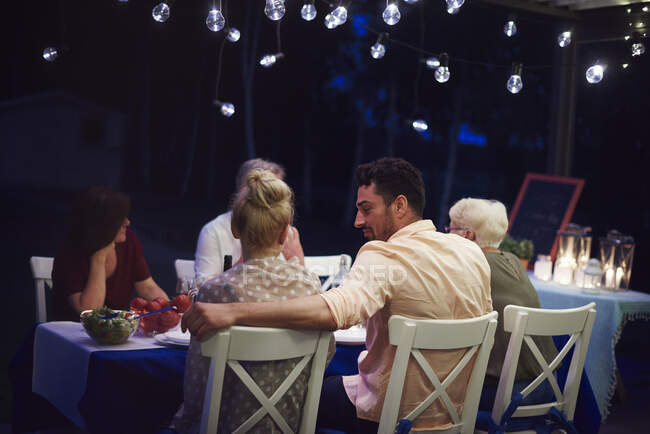 Gruppe von Menschen sitzt am Tisch und genießt das Essen — Stockfoto