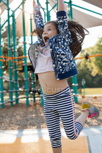 Девочка играет и веселится на детской площадке — стоковое фото