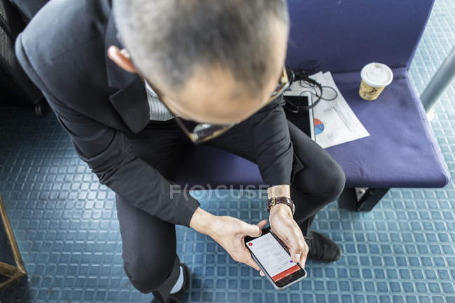 Empresario en ferry de pasajeros mirando el teléfono inteligente - foto de stock