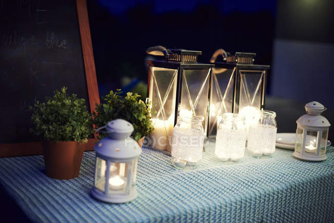 Conjunto de mesas, ao ar livre, com lanternas iluminadas — Fotografia de Stock