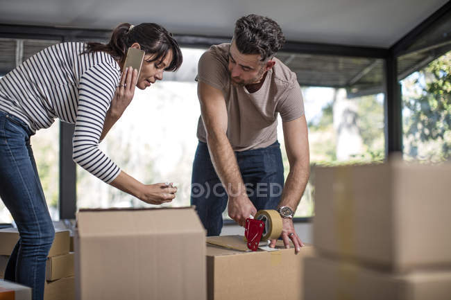 Couple packing belongings into cardboard boxes — Stock Photo