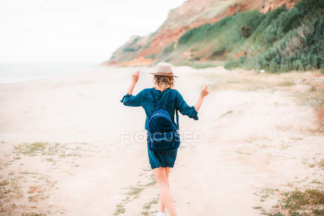 Вид ззаду жінка танцює вздовж пляжу — стокове фото