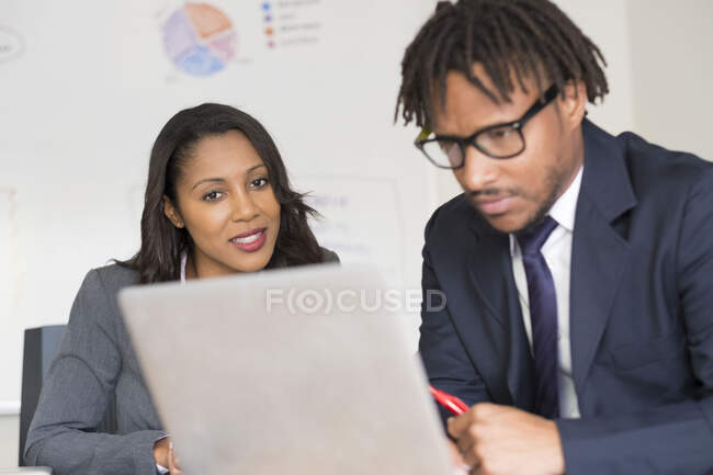 Uomo d'affari e donna d'affari, in carica, guardando lo schermo del portatile — Foto stock