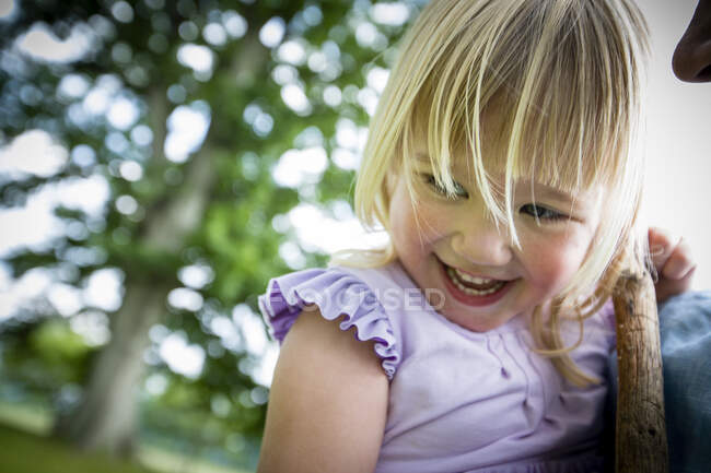 Menina de cabelos loiros bonito com franja segurando pau — Fotografia de Stock