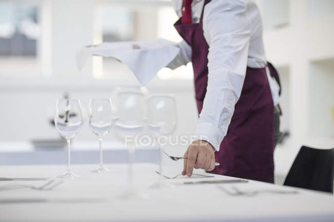 Kellner deckt Tisch im Restaurant, Mittelteil — Stockfoto