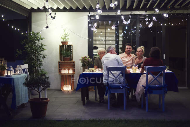 Группа людей, сидящих за столом и наслаждающихся едой — стоковое фото