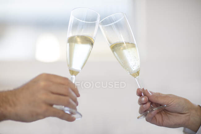 Paar hält Champagnergläser, prostet zu, Nahaufnahme — Stockfoto