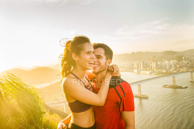 Homem e mulher corredores abraçando e sorrindo ao ar livre — Fotografia de Stock