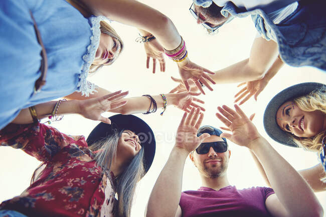 Low angle view of young adult friends dancing in circle at festival — Stock Photo