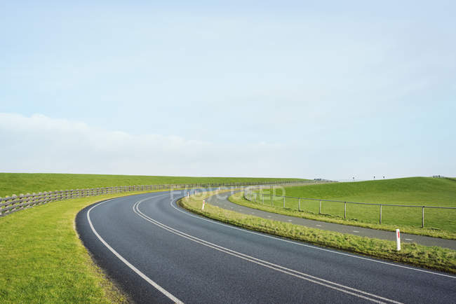 Empty road through the dyke besides the Waddense, Holwerd, Friesland, Netherlands — Stock Photo