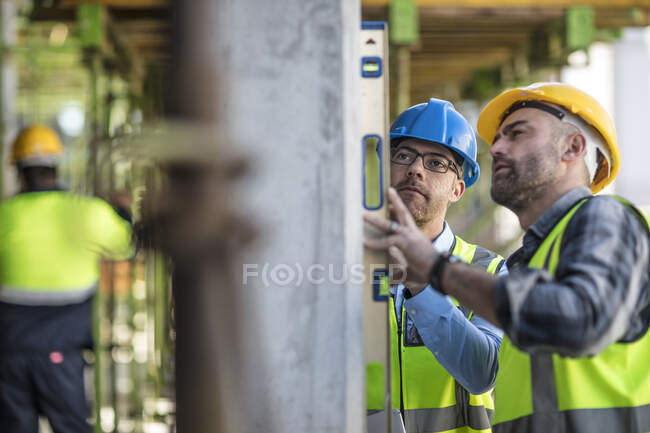 Project manager and construction worker using spirit level — Stock Photo