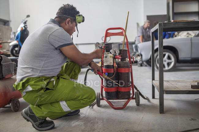 Hombre preparando plantilla de soldadura en taller de reparación de carrocería - foto de stock