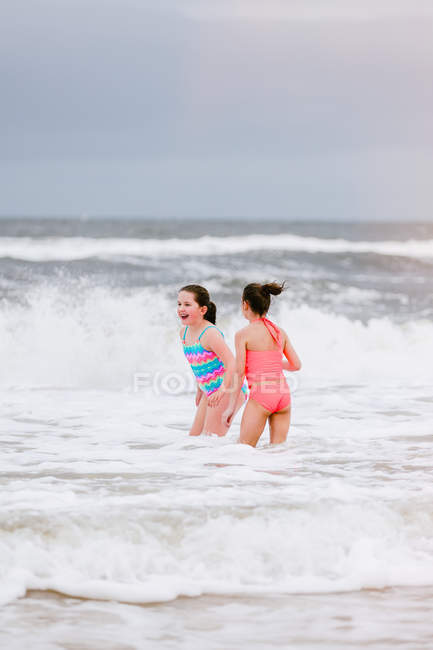 Two girls standing in ocean waves, Dauphin Island, Alabama, USA — Stock Photo