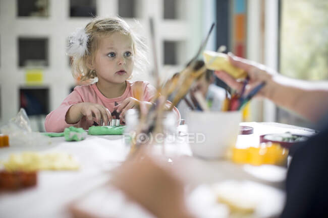 Chica jugando con arcilla - foto de stock