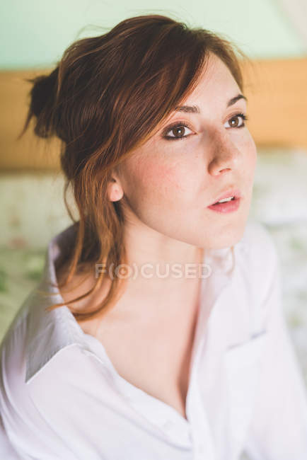 Portrait of beautiful young woman on bed gazing — Stock Photo