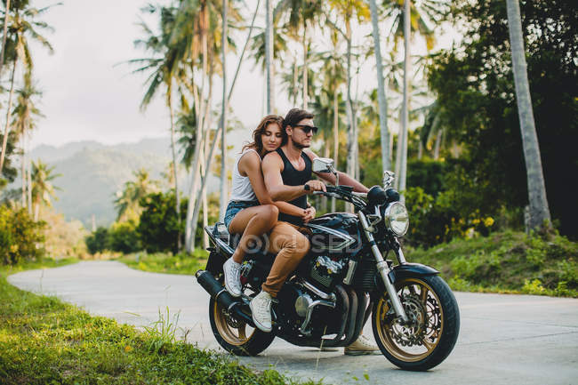 Pareja joven montando en motocicleta en camino rural, Krabi, Tailandia - foto de stock