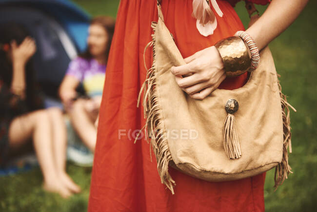 Partie médiane de la femme boho avec sac à bandoulière à pompons au festival — Photo de stock