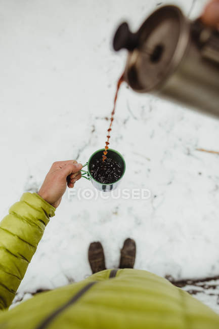 Vista personale prospettiva di escursionista maschio versando caffè dalla fiaschetta — Foto stock