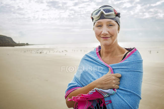 Mulher com envoltório sobre ombros na praia — Fotografia de Stock