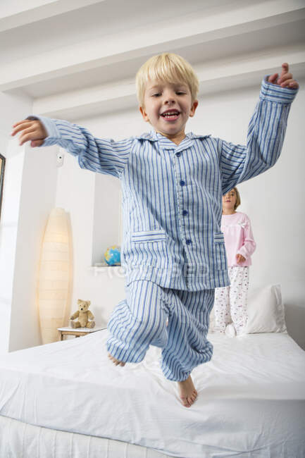Boy and female twin jumping from bed — Stock Photo