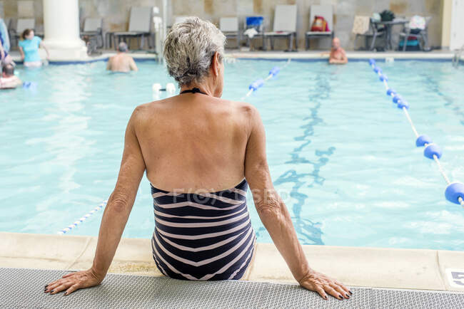 Senior mulher à beira da piscina — Fotografia de Stock