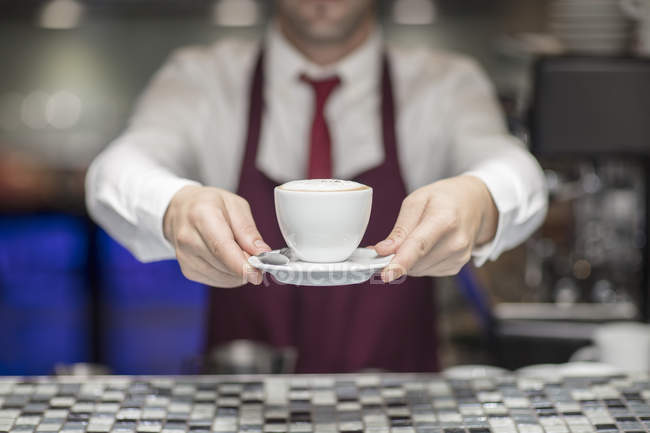 Mid section view of Waiter in restaurant holding freshly made coffee — Stock Photo
