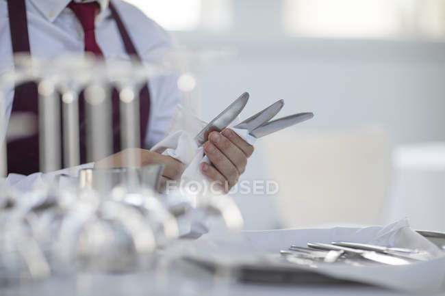 Mesero poniendo mesa en restaurante, sección media - foto de stock