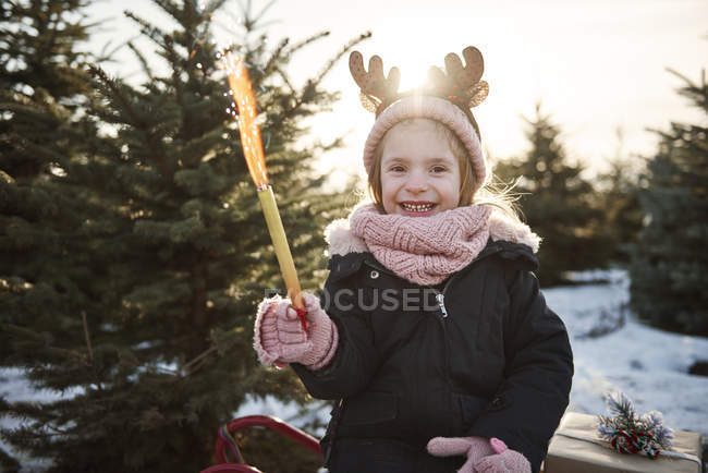 Girl in christmas tree forest wearing antlers, portrait — Stock Photo