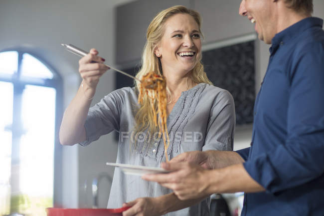 Mulher e homem servindo comida de panela — Fotografia de Stock