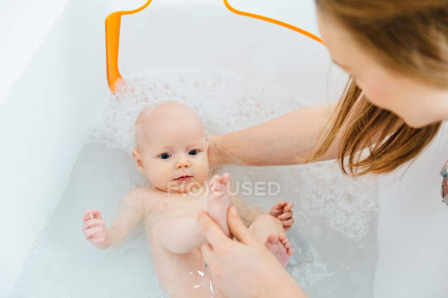 Alto ángulo vista de madre bañando bebé hija - foto de stock