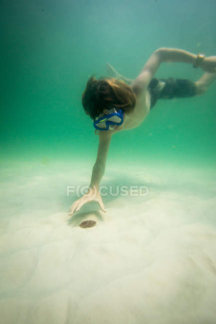 Vue sous-marine du garçon adolescent avec masque de natation sur le fond marin — Photo de stock