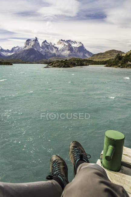 Обрезанное изображение туриста, сидящего над Грей-Лейк, Национальный парк Торрес-дель-Пайне, Чили — стоковое фото