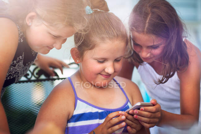 Hermanos disfrutando del juego en el teléfono inteligente - foto de stock