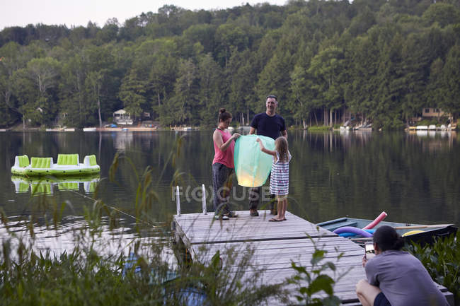 Padre e figlie rilasciando lanterna cielo e donna evento fotografico — Foto stock