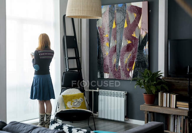 Woman looking out window at home — Stock Photo