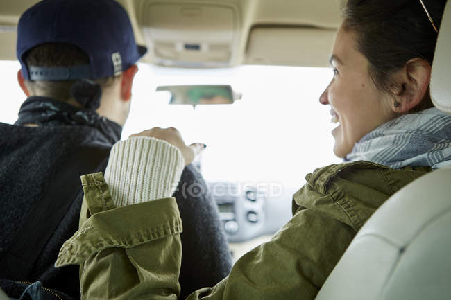 Young couple in car and woman touching man shoulder — Stock Photo