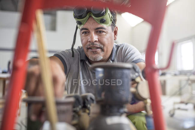 Soldador en el trabajo en taller de reparación de carrocerías - foto de stock