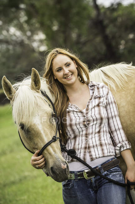 Портрет молодої жінки, що стоїть з конем — стокове фото