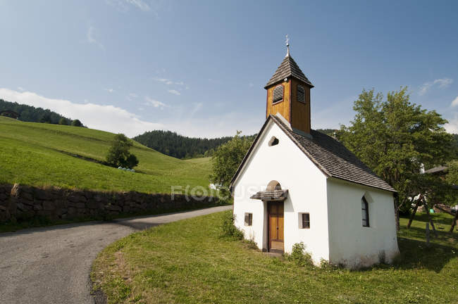 Camino rural e iglesia de San Pietro, Valle de Funes, Dolomitas, Italia - foto de stock