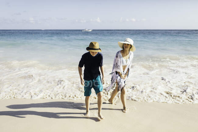 Mère et fils marchant sur la plage — Photo de stock