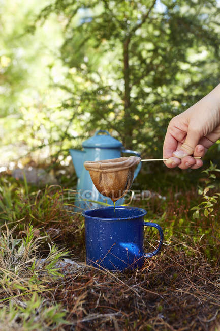 Primer plano de la mujer haciendo café en el bosque - foto de stock