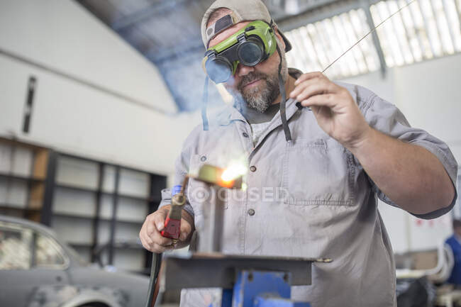 Mann schweißt in Karosseriewerkstatt — Stockfoto