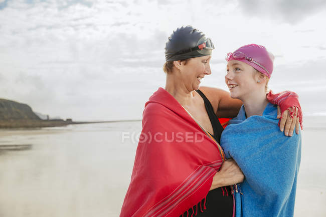 Madre e figlia in piedi sulla spiaggia con scialli — Foto stock