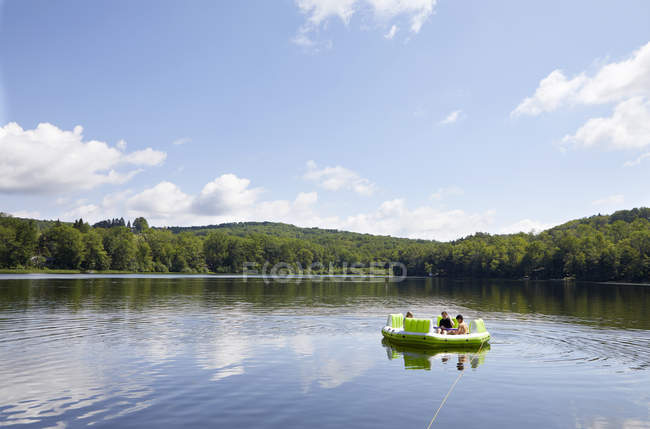 Троє дітей на надувному човні на озері — стокове фото