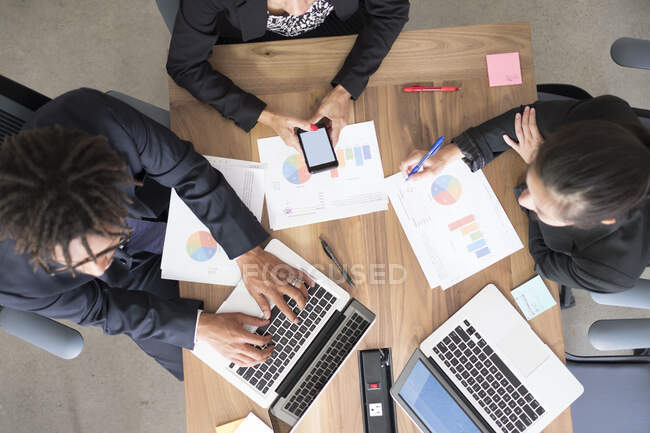 Empresário e empresárias, em reunião de escritório, usando laptops, olhando para os dados, vista aérea — Fotografia de Stock