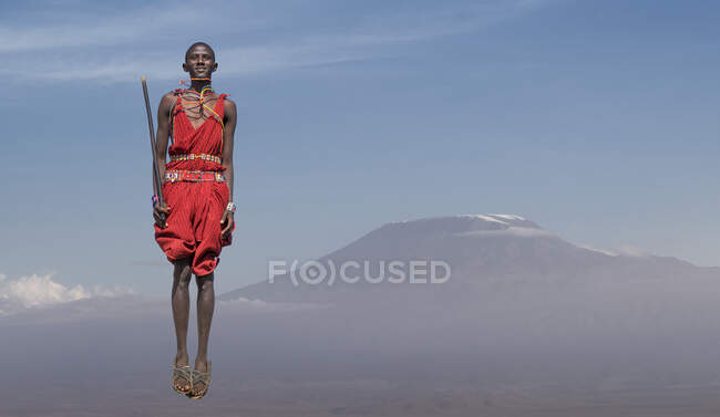 Masai man with traditional dress jumping in front of Mount Kilimanjaro, Amboseli, Rift Valley, Kenya — Stock Photo
