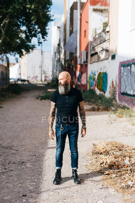 Mature male hipster standing in alleyway — Stock Photo