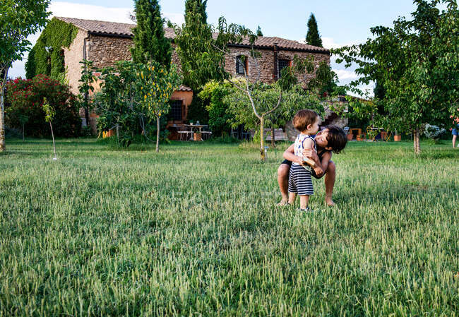 Brothers playing in garden of farmhouse — Stock Photo